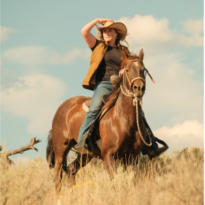 Cowgirl riding a horse with a crossover saddle